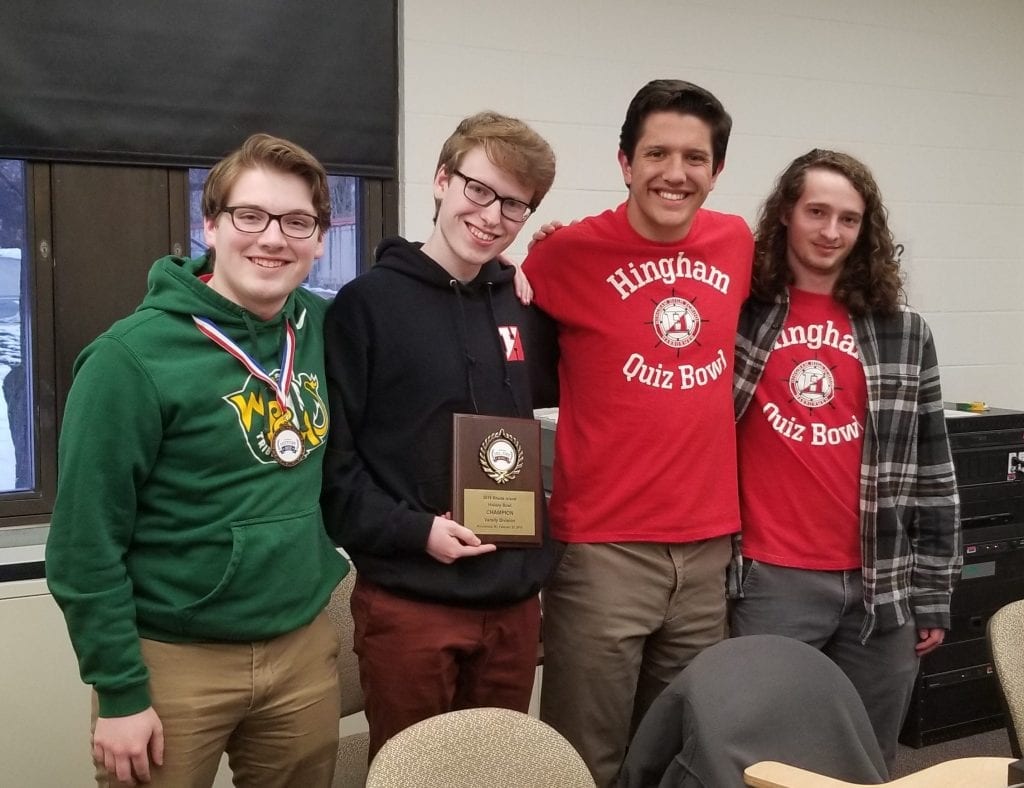 Caption for the photo is: Jack Collins, Nate Webber, James Winikoff, and Emmet Lewiecki proudly display their RI State Varsity Bowl NHBB Champion plaque. Jack Collins also earned a medal for finishing third in the bee, the individual competition. 