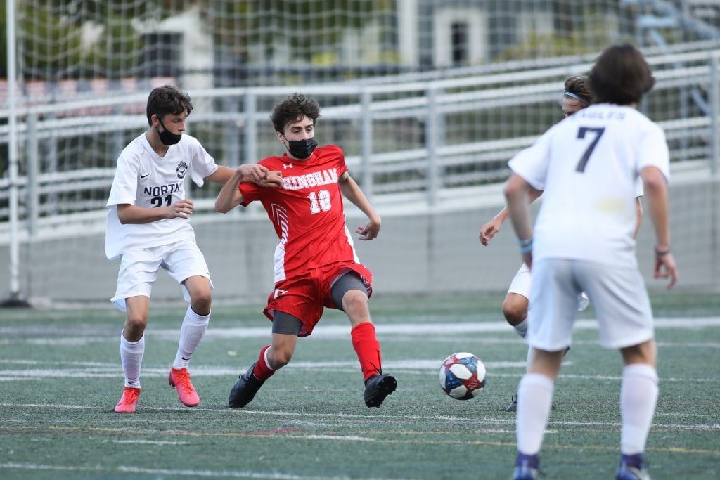 Junior Brian Dalimonte fights off defenders as the Harbormen hold on to win 3-2.