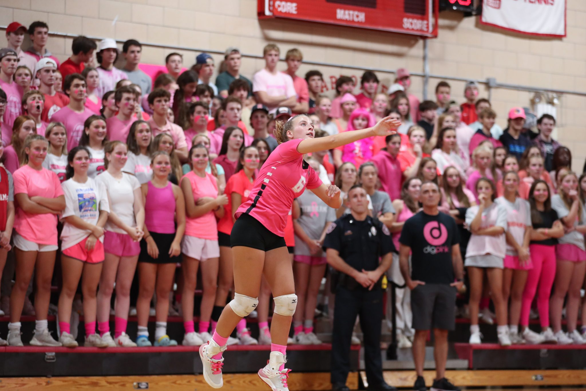 Senior Alex Kennedy serves in front of a sea of pink to start the match for Hingham's Annual Dig Pink Fundraiser. 